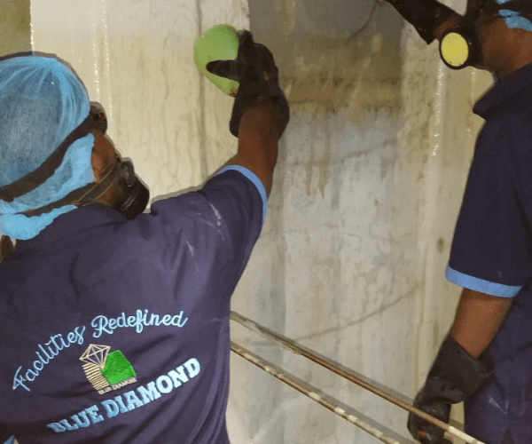 people standing and cleaning inside water tank