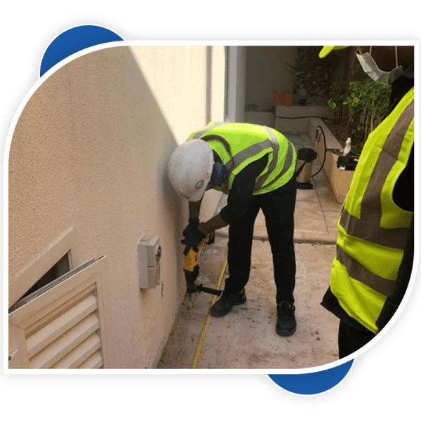 man drilling the hole with driller for controlling the termites