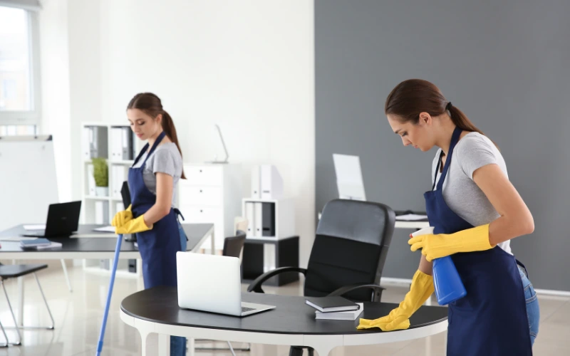 two women standing cleaning table and floor