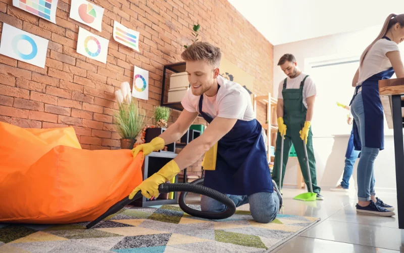 A group of cleaners are cleaning the floor and glass.