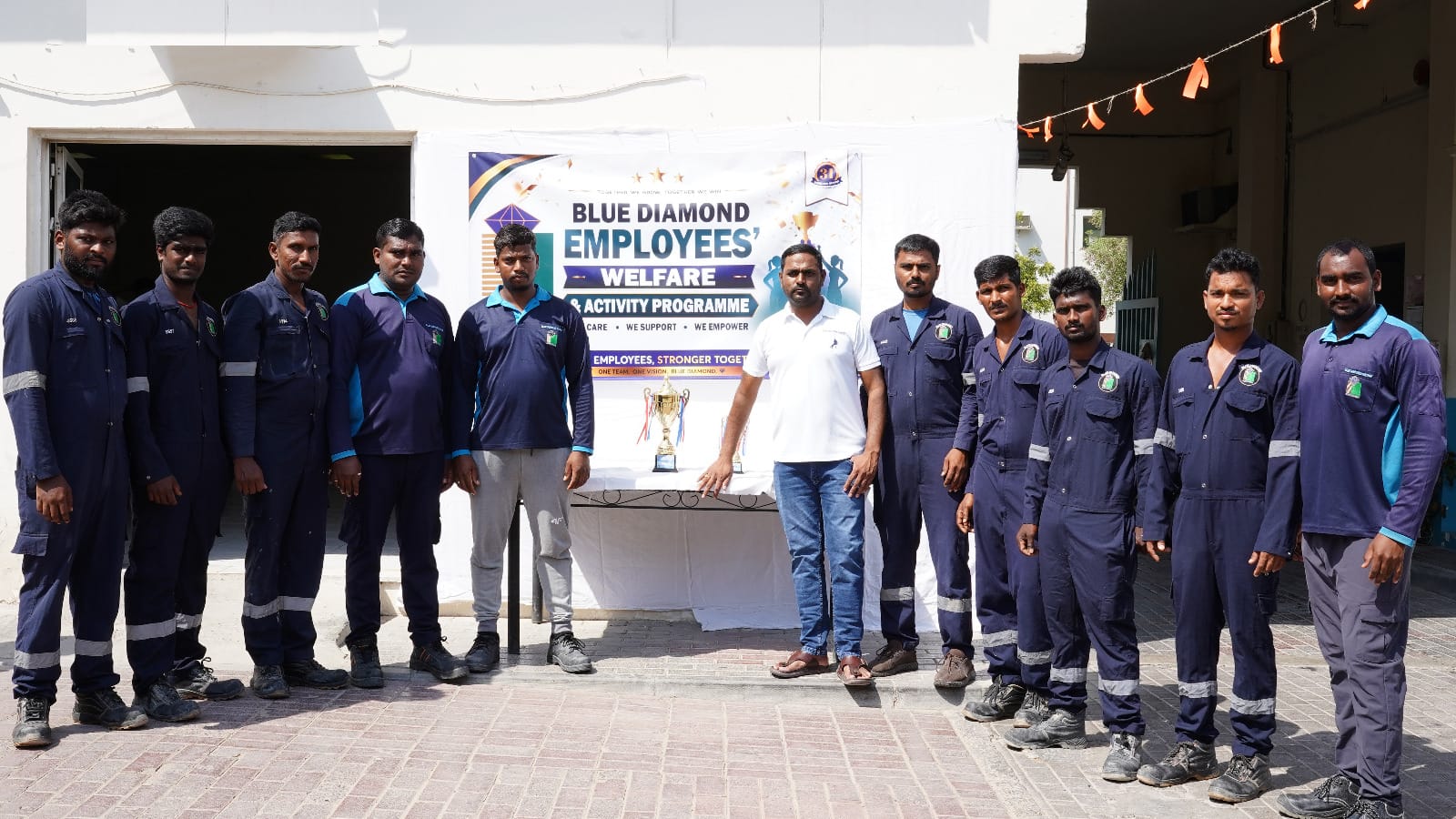 Group photo of Blue Diamond Group employees after the Tug of War Competition at Sonapur Camp.